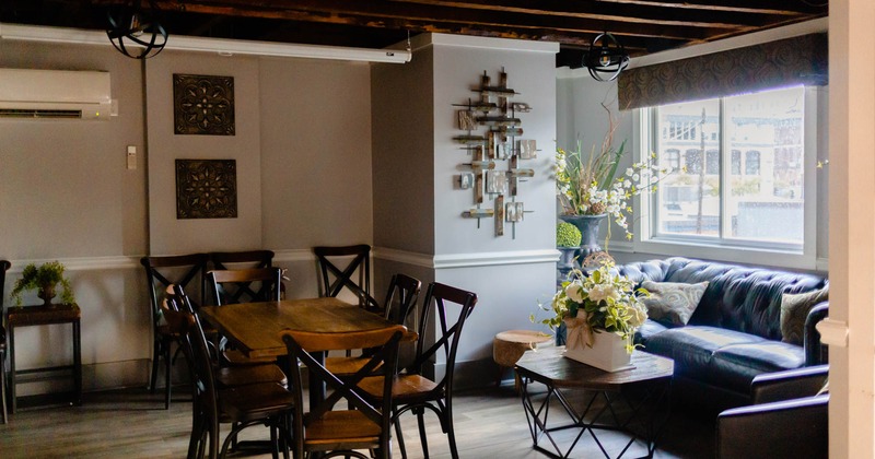 Interior, table and lounge seating, wall decorations and plant pots in lounge area