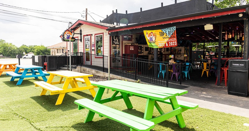 Exterior, different colored picnic tables in front of the restaurant