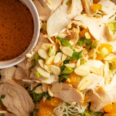 Chinese chicken salad with almonds, mandarin oranges, and red dipping sauce.