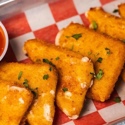 Close up of mozzarella wedges on a red checkered paper.
