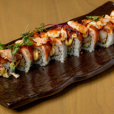 Crawfish Lover Roll served on a dark, ceramic platter and garnished with microgreens.