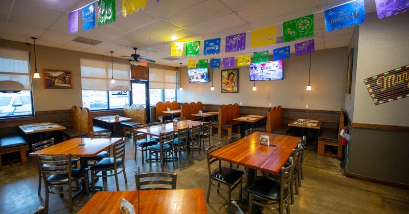 Interior, dining area, wooden top tables for four and eight, seating booths, entrance