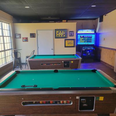 Interior, part of a room with pool tables and arcade game machine