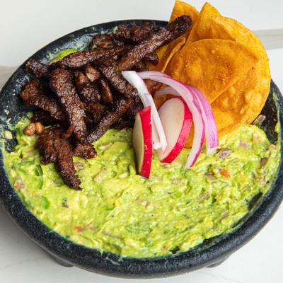Guacamole topped with crispy fried ribeye steak and served with tortilla chips.
