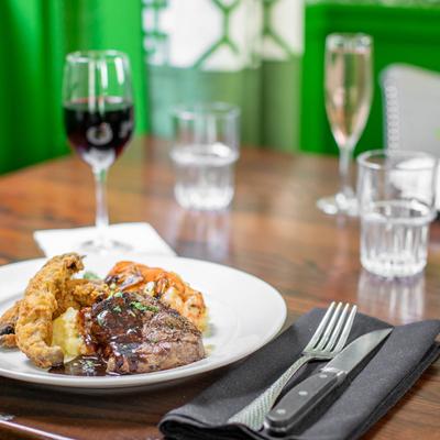 Grilled Filet Mignon & Marinated Shrimp plate on a table with wine