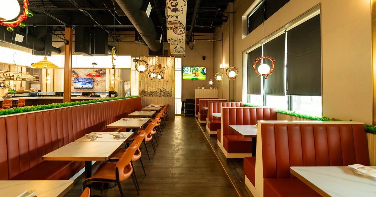 Red booth seating, wooden chairs, hanging lights, and festive decorations along the divider