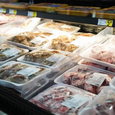 Packaged raw meat trays displayed in a refrigerated case.