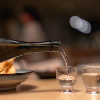 Sake being poured into a shot glass.