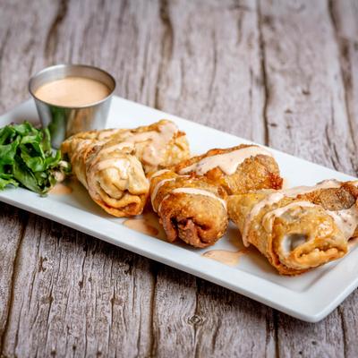 Steak & Cheese Eggrolls served with a cup of chipotle sauce.