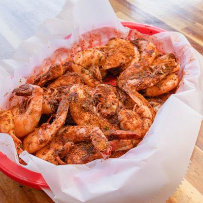 Seasoned shrimp in a red paper-lined basket.