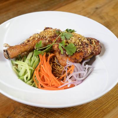 Grilled chicken with fresh vegetables, herbs, and crushed nuts.