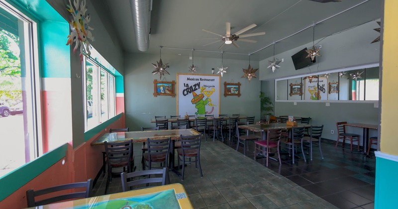 Interior of a Mexican restaurant with colorful walls, star-shaped hanging lights, and a mural featuring a cactus