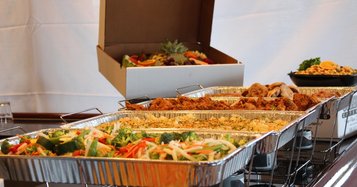 Buffet setup with trays filled with various types of food