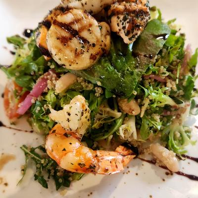 Seafood salad with shrimp, scallops, and leafy greens.
