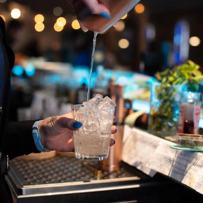 Hands serving a cocktail.