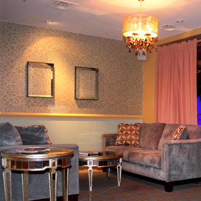 A well-furnished room with sofas, round side table, and chandelier emitting soft light.