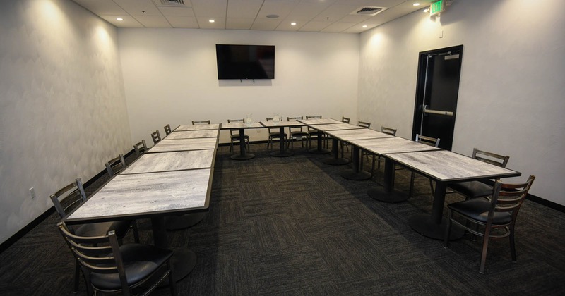 Interior, room with tables and chairs, TV screen on the wall