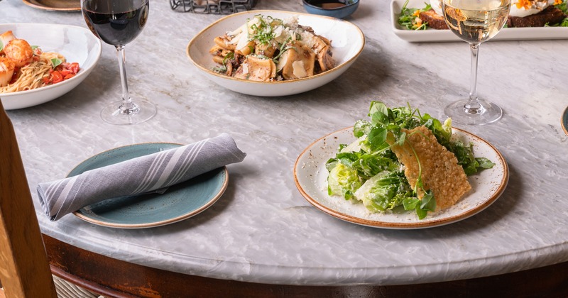 Elegant dining table featuring assorted dishes, and red and white wine glasses