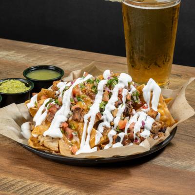 large plate of nachos with beer.