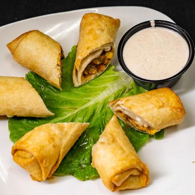 Southwest Egg Rolls served over lettuce leaf with a dipping sauce on the side.