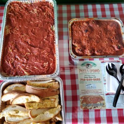 Full pan of spaghetti in meat sauce and half pan of 20 meatballs with garlic bread.