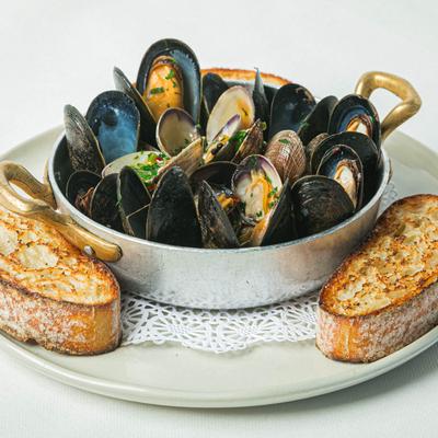 Clams and mussels in white wine and tomato sauce, served with grilled bread.