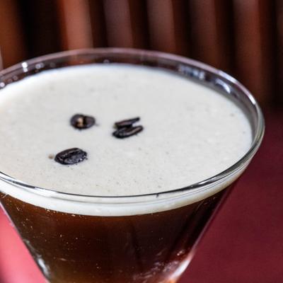 Espresso Martini garnished with three coffee beans, close-up.