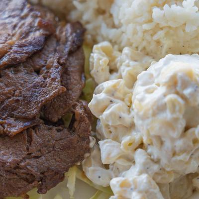 BBQ beef served with rice and pasta salad.