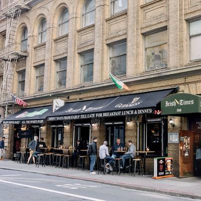 The exterior of the Irish Times pub, with several guests in the outdoor seating area.