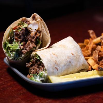 Shaved steak tortilla wrap served with fries.