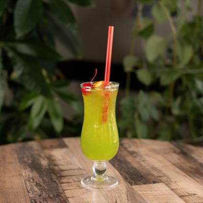 Islander cocktail in hurricane glass with cherry and orange garnish.