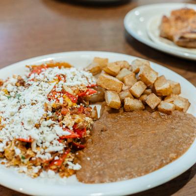 Chilaquiles plate with beans and potatoes.