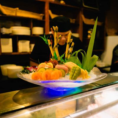 Sushi Deluxe plate is placed on a sushi bar counter.