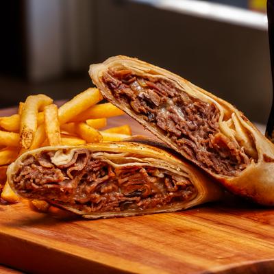 Philly cheesesteak wrap with fries.