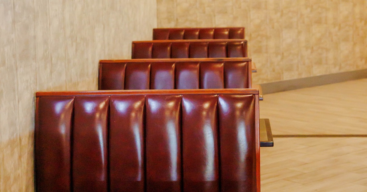 Interior view of a restaurant with brown leather booths and light wood flooring