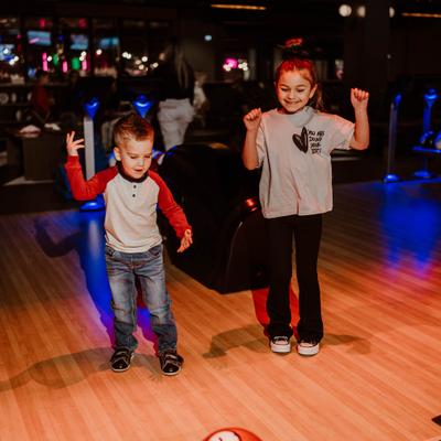 2 kids bowling and having fun.