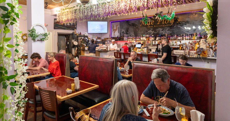 Interior, booths, guests eating, bar behind