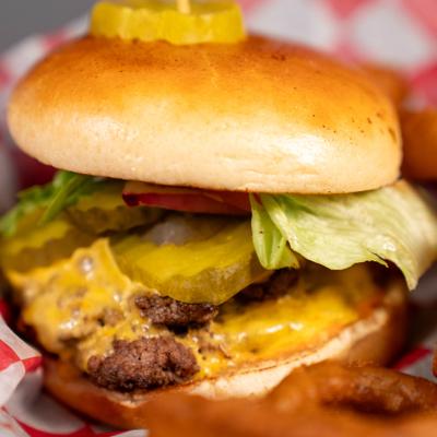 Gaslight Classic Burger with American cheese, lettuce, tomato, onion, and pickle.
