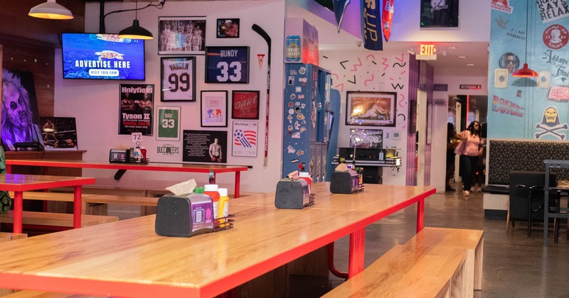 Interior, wooden tables and benches, framed jerseys and stickers on the walls