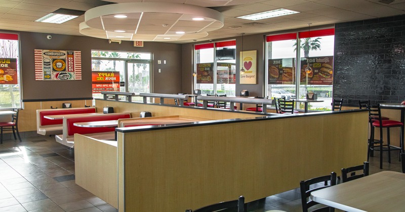 Interior with red and beige seating, large windows and wall decorations.