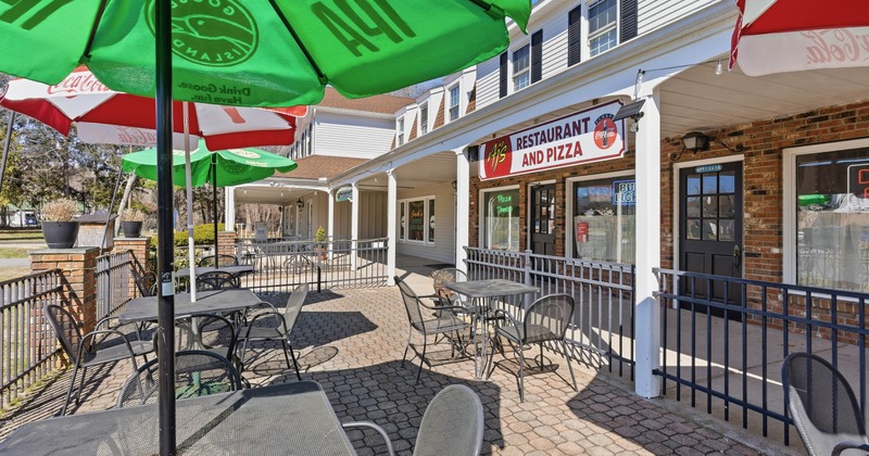 Outdoor seating area of a restaurant with metal tables and chairs