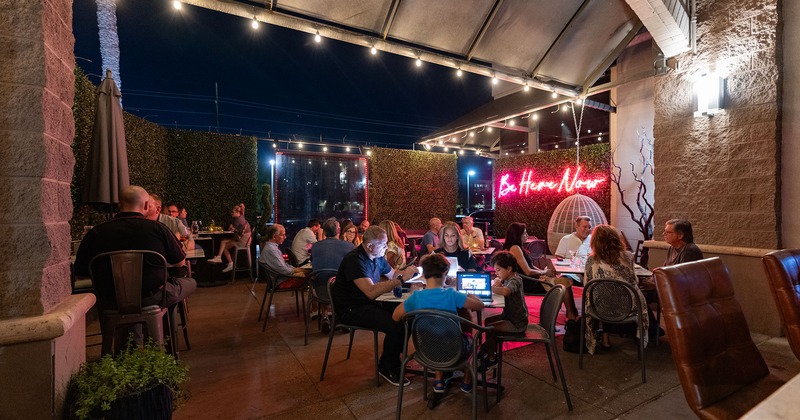 Patio at night, seating area full of guests