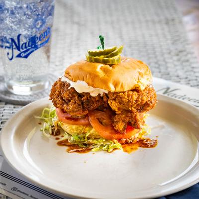 Crispy fried Nashville hot chicken sandwich with lettuce, tomato, cheese, and pickles.