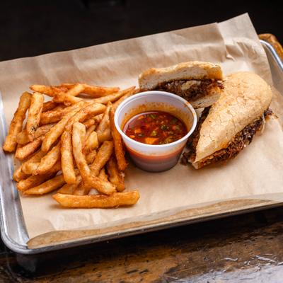 Shredded Beef Sandwich served with fries and a dipping sauce.
