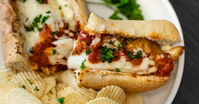 Chicken Parm Sandwich served with chips, close up