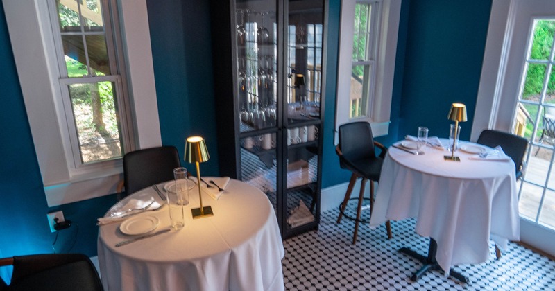 Interior, two round tables ready for guests