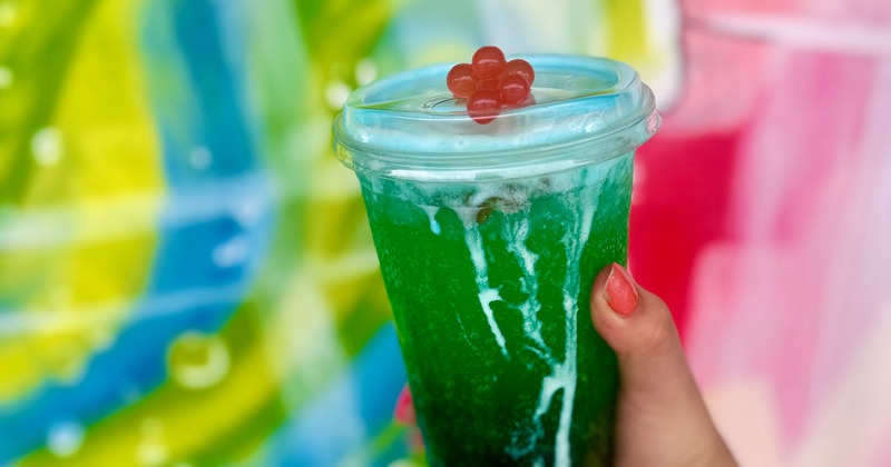Hand holding a iced drink in a plastic cup