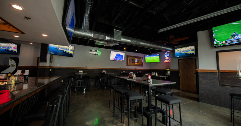 Interior, dining area with five TVs on the walls