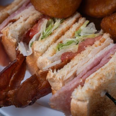 A close-up of a club sandwich with turkey, bacon, lettuce, and tomato.