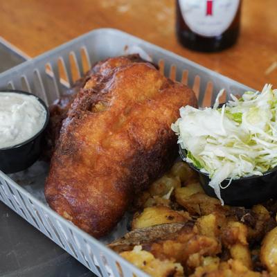 Beer-battered fried fish with tartare sauce, slaw, and seasoned potatoes.